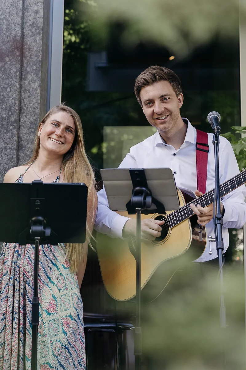 Samira und Jakob vor der Glasfassade, Hochzeitsduo Jamira aus München